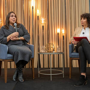 Natasha Trethewey and Anna Haskins sit side-by-side on a stage in blue chairs