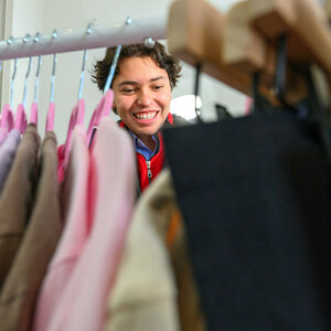 A woman looks through a rack of clothes
