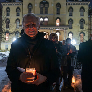 University of Notre Dame president Rev. John I. Jenkins, C.S.C. holds a candle on a snowy evening