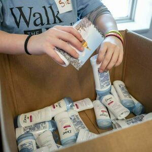 A student fills a box with sticks of deodorant